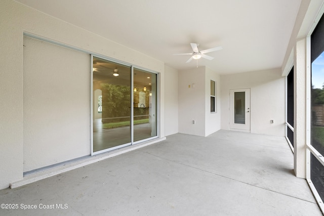 unfurnished sunroom featuring ceiling fan