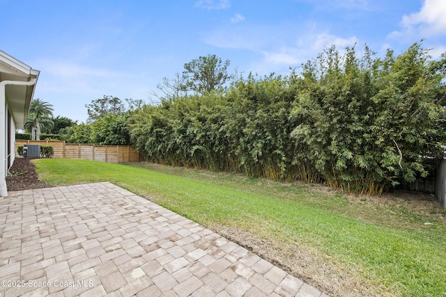 view of yard featuring central AC unit and a patio