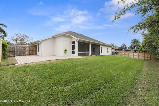 rear view of house featuring a patio area, a sunroom, and a yard