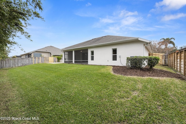 rear view of property featuring a sunroom and a lawn