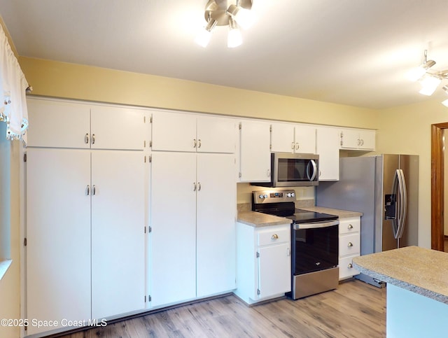 kitchen featuring light hardwood / wood-style floors, white cabinets, and appliances with stainless steel finishes