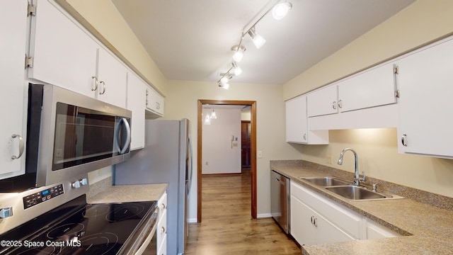 kitchen featuring sink, white cabinets, light hardwood / wood-style floors, and appliances with stainless steel finishes