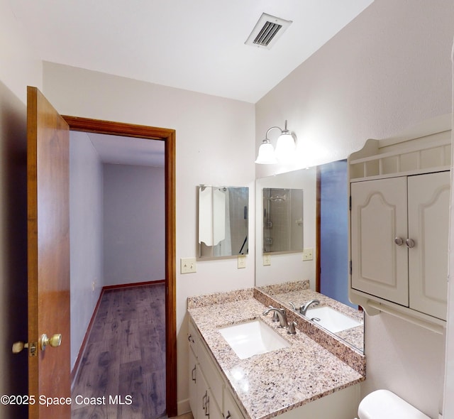 bathroom featuring hardwood / wood-style flooring, toilet, and vanity