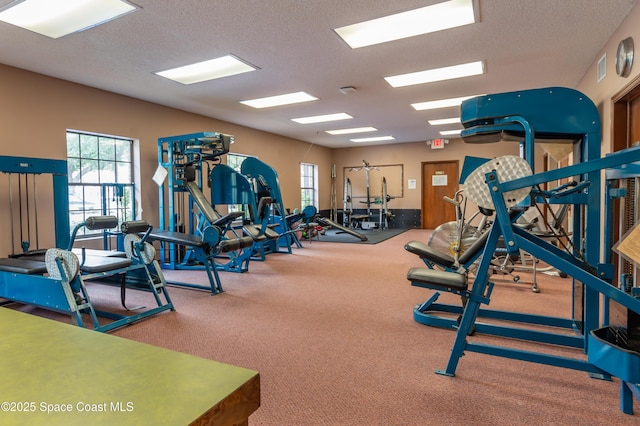 exercise room with a textured ceiling and carpet floors