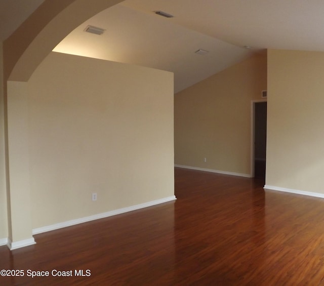 empty room featuring dark hardwood / wood-style flooring and vaulted ceiling