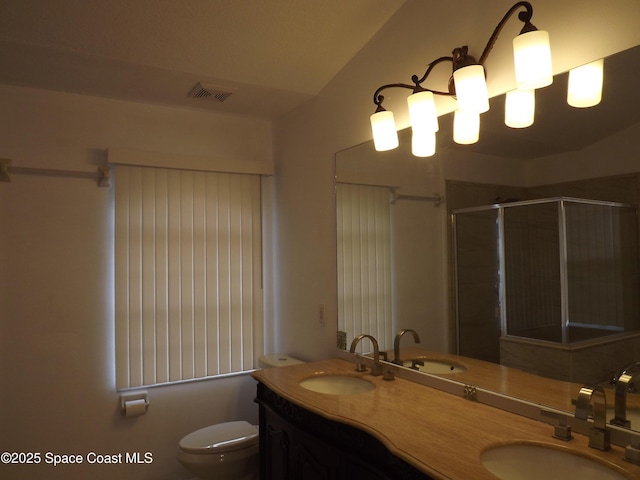 bathroom with walk in shower, vanity, and toilet