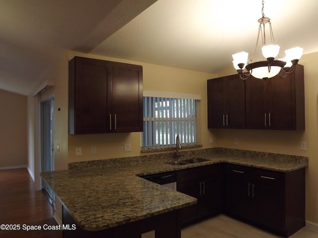 kitchen with decorative light fixtures, a chandelier, dark stone counters, and dark brown cabinetry