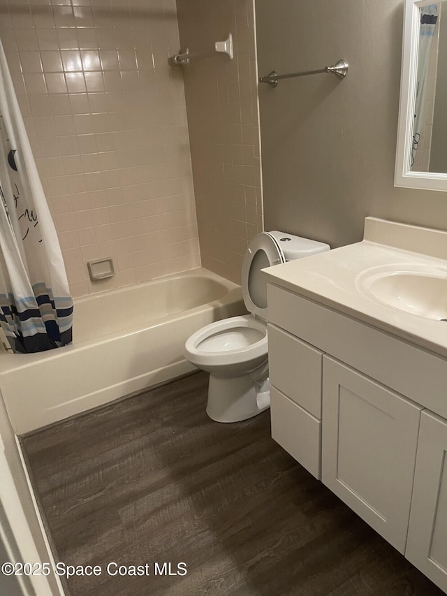 full bathroom featuring toilet, hardwood / wood-style flooring, shower / bathtub combination with curtain, and vanity