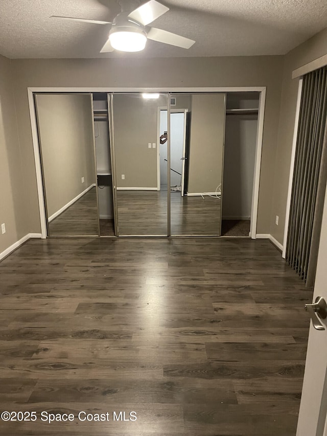 unfurnished bedroom with dark hardwood / wood-style flooring, a textured ceiling, and ceiling fan