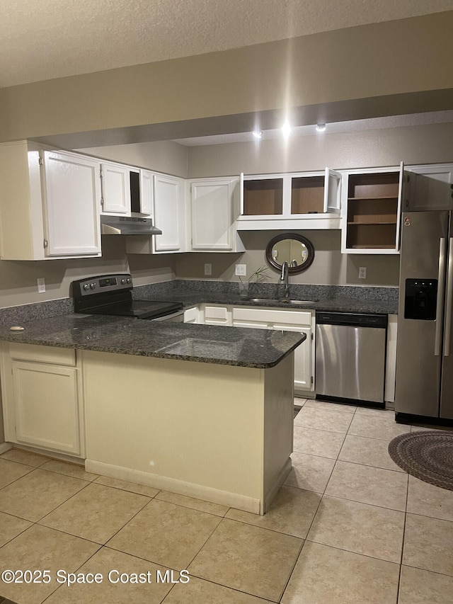 kitchen with a textured ceiling, stainless steel appliances, white cabinets, light tile patterned flooring, and sink