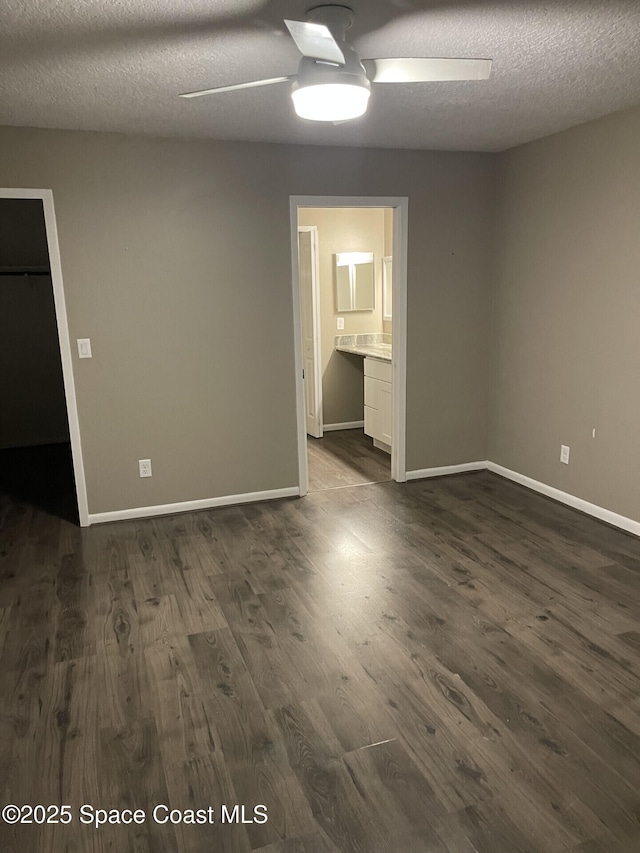 empty room featuring a textured ceiling and dark hardwood / wood-style floors