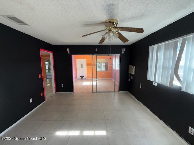 unfurnished room featuring ceiling fan and a textured ceiling