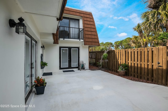 view of patio with french doors and a balcony