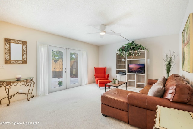 living room with french doors, ceiling fan, carpet flooring, and a textured ceiling