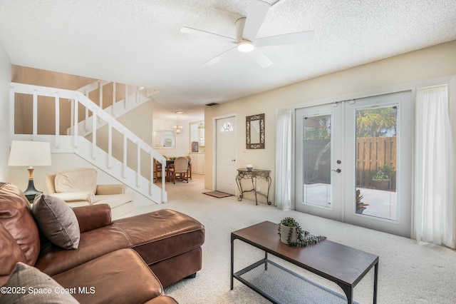 living room with light carpet, ceiling fan, french doors, and a textured ceiling