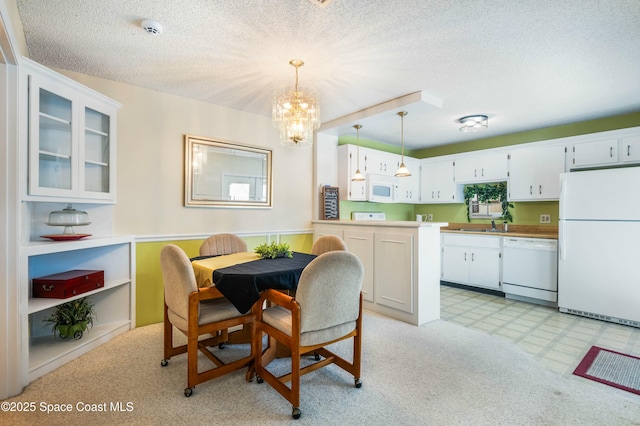 dining space featuring sink, an inviting chandelier, and a textured ceiling