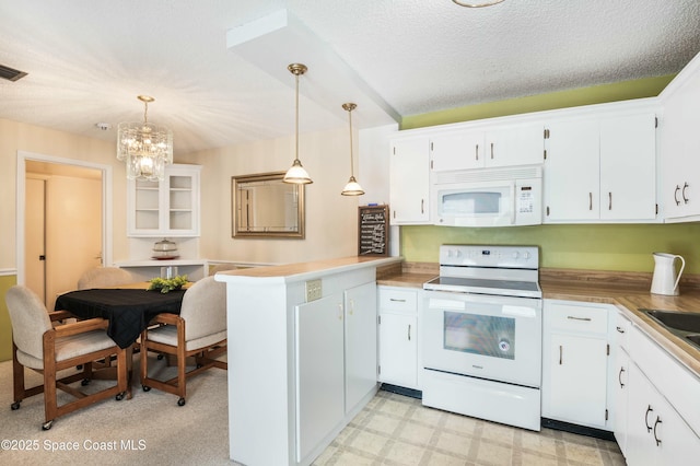 kitchen featuring white cabinetry, decorative light fixtures, white appliances, and kitchen peninsula