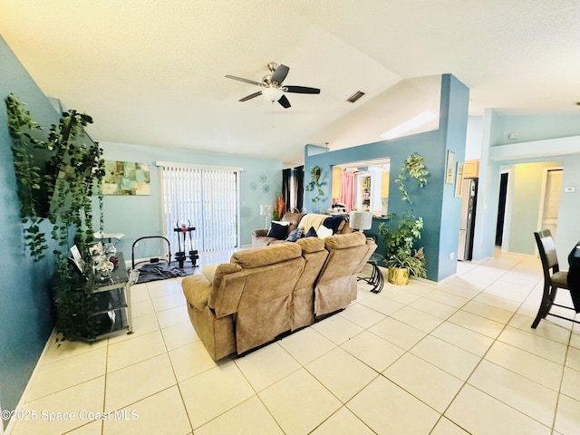 living room featuring ceiling fan, vaulted ceiling, a textured ceiling, and light tile patterned floors