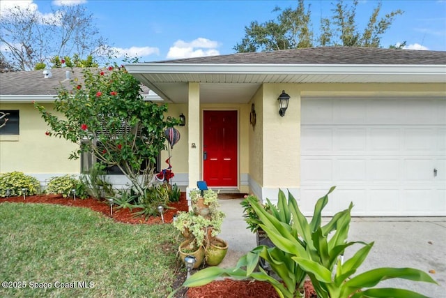 entrance to property with a garage and a yard