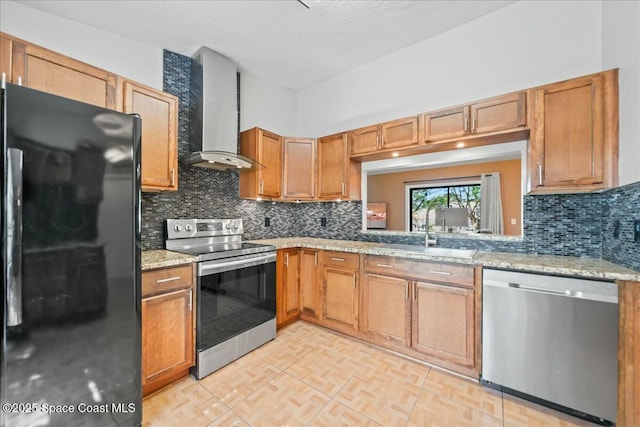 kitchen with appliances with stainless steel finishes, decorative backsplash, light stone counters, and wall chimney range hood