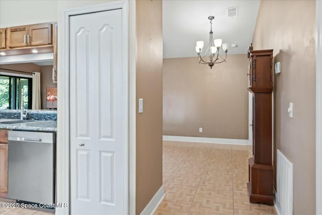 hallway featuring light parquet floors and a chandelier