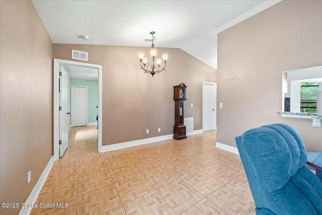 interior space with light parquet flooring, vaulted ceiling, and a notable chandelier