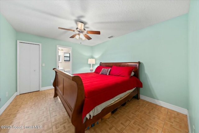 bedroom featuring ceiling fan, light parquet flooring, and a textured ceiling