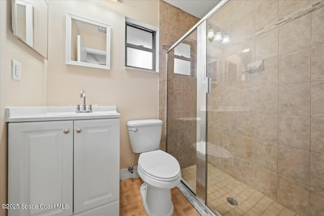 bathroom with toilet, a shower with door, and vanity