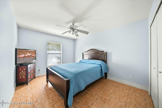 bedroom featuring ceiling fan, a closet, and light parquet floors