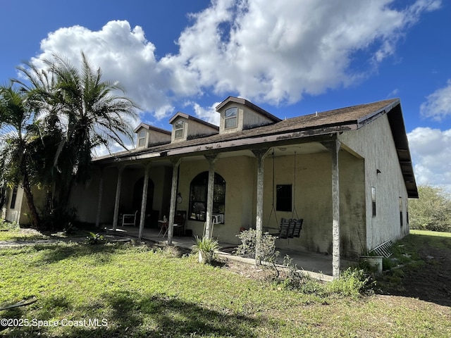 back of property featuring a patio and a yard