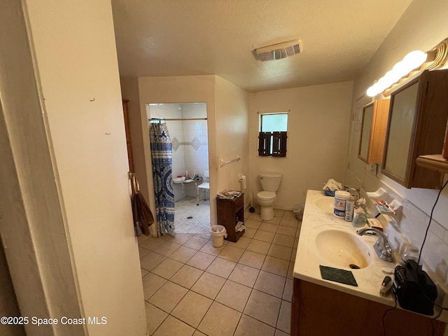 bathroom with toilet, a textured ceiling, vanity, curtained shower, and tile patterned flooring