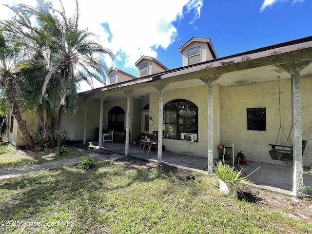 back of property featuring a lawn and a patio area