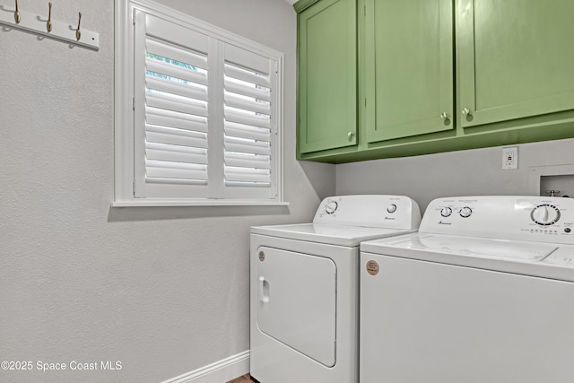 laundry area featuring washer and dryer and cabinets