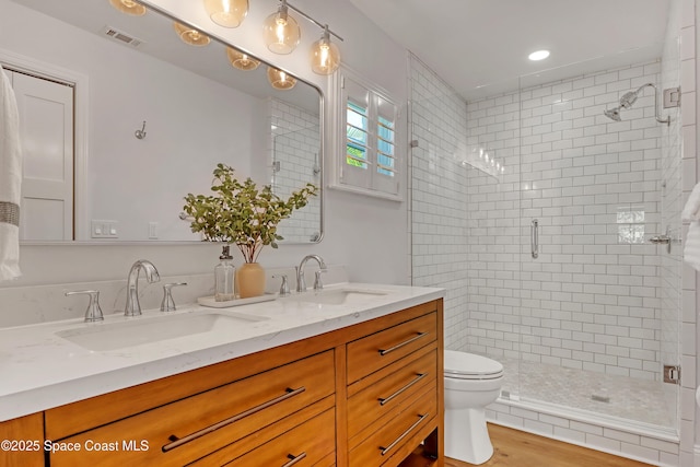 bathroom featuring toilet, an enclosed shower, vanity, and hardwood / wood-style floors