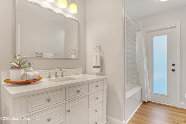 bathroom with wood-type flooring, vanity, and shower / tub combo with curtain