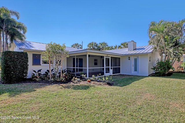 view of front facade with a front yard and a sunroom