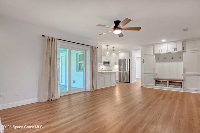 unfurnished living room featuring ceiling fan and light hardwood / wood-style floors