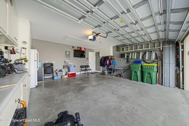 garage featuring a garage door opener, white fridge, and electric panel