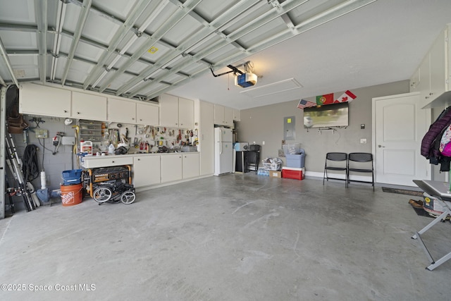 garage with a workshop area, a garage door opener, white refrigerator, and electric panel