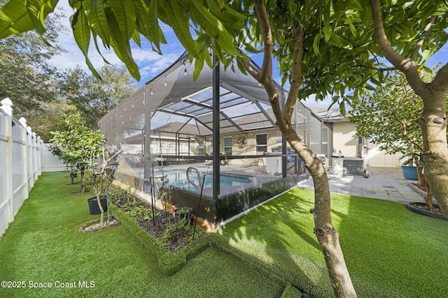 view of pool with glass enclosure, a patio area, and a yard