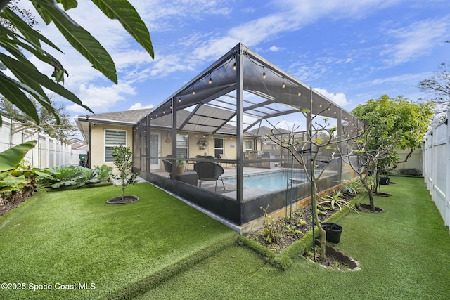 rear view of house featuring a lanai, a yard, and a fenced in pool