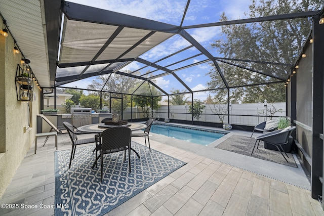 view of swimming pool with a lanai, exterior kitchen, a patio area, and a grill