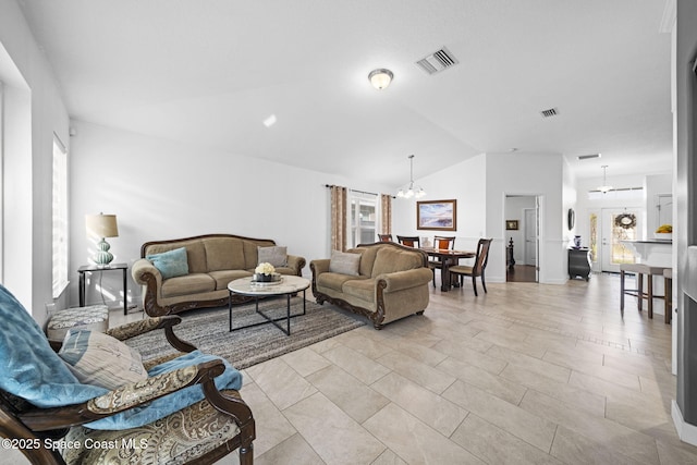 living room with vaulted ceiling and an inviting chandelier