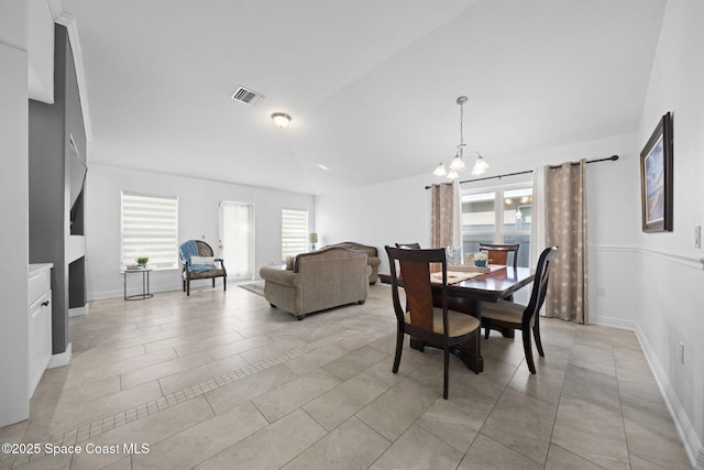 dining room featuring light tile patterned floors, plenty of natural light, and a notable chandelier