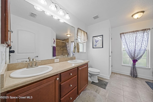 bathroom with toilet, a textured ceiling, plenty of natural light, and curtained shower