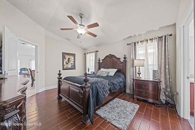 bedroom with ceiling fan, vaulted ceiling, multiple windows, and a textured ceiling