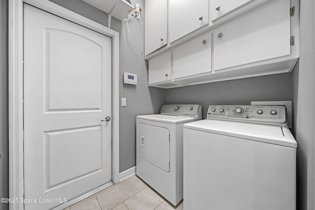 washroom featuring cabinets, light tile patterned floors, and independent washer and dryer