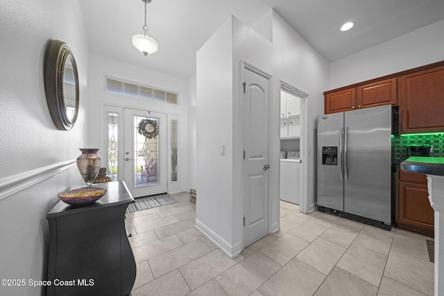 entryway with washer / dryer and light tile patterned flooring