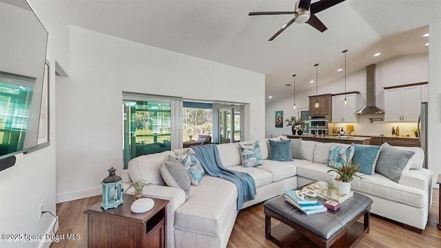 living room with hardwood / wood-style flooring, ceiling fan, and high vaulted ceiling