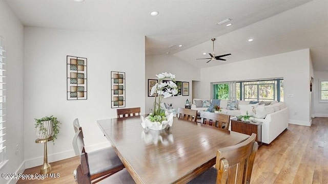 dining space with vaulted ceiling, ceiling fan, and light wood-type flooring